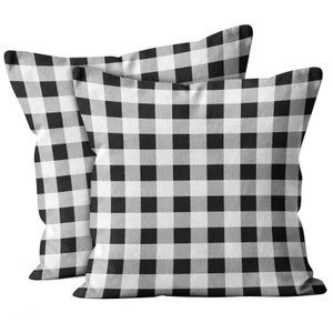 May include: Two black and white gingham throw pillows. The pillows are made of a soft, comfortable fabric and have a classic checked pattern.