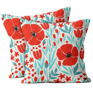 May include: Two decorative throw pillows with a floral pattern. The pillows feature a turquoise blue background with red poppy flowers and green leaves.