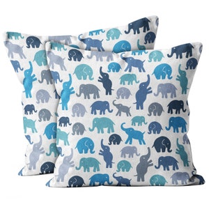 May include: Two square cushions featuring a pattern of blue elephants on a white background. The elephants are in various shades of blue and in different poses. Ideal for a living room or bedroom.