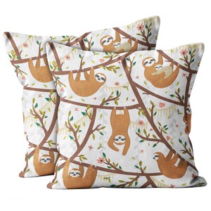 May include: Two white pillowcases with a brown sloth pattern. The sloths are hanging from branches with pink flowers and green leaves. The sloths are brown with white faces and black eyes.