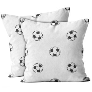 May include: Two white pillowcases with a black soccer ball pattern. The pillowcases are made of a soft, comfortable fabric.