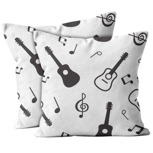 May include: Two white pillowcases with a black and white musical pattern. The pattern features guitars, treble clefs, and musical notes.