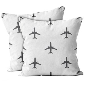 May include: Two white pillowcases with a repeating pattern of dark gray airplane silhouettes.