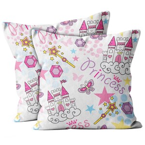 May include: Two white pillowcases with a pink and white princess theme. The pillowcases feature a repeating pattern of castles, stars, butterflies, wands, and the word "Princess".