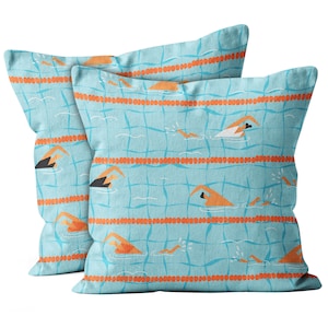 May include: Two blue and orange pillow covers with a repeating pattern of swimmers in a pool. The pattern features orange swimmers on a blue tiled background with orange lines.
