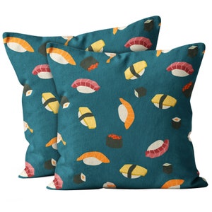 May include: Two teal blue pillowcases with a repeating pattern of colorful sushi rolls. The pillowcases are made of a soft, comfortable fabric and feature a variety of sushi designs.