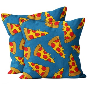 May include: Two square cushions featuring a repeating pattern of cartoon pizza slices on a blue background. The pizza slices have yellow cheese and red pepperoni. A fun and colourful addition to any room.