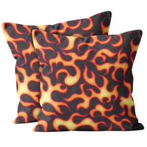 May include: Two decorative throw pillows with a black background and a repeating pattern of orange and yellow flames.