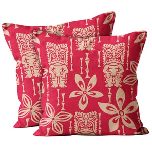 May include: Two red throw pillows with a repeating pattern of tiki faces and flowers. The pillows are made of a soft, textured fabric.