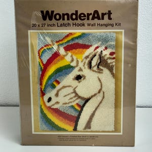 Könnte beinhalten: WonderArt-Haken-Wandbehang-Set mit Einhorn- und Regenbogen-Design. Fertige Größe: 50 x 69 cm. Das Set enthält Material und Muster zur Herstellung eines strukturierten Wandbehangs.