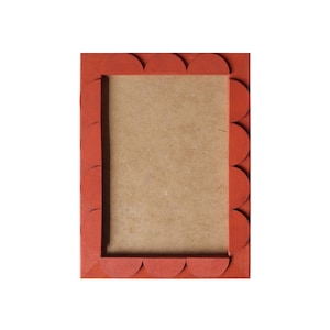 Op de afbeelding: Een rood fotolijstje met een gegolfde rand. Het lijstje is leeg en klaar voor een foto.