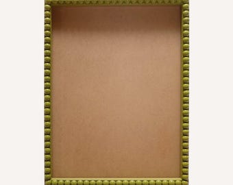May include: A rectangular picture frame featuring a bright lime green border decorated with a continuous row of small, uniform spheres. The center of the frame is filled with a flat, light brown, solid-colored backing material.