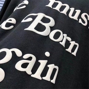 May include: Black sweatshirt with white text that reads "You must be born again".