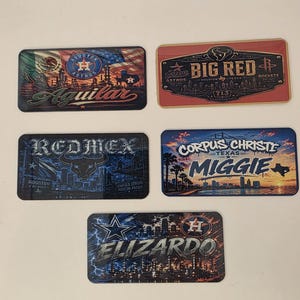 May include: Five rectangular license plate-style signs featuring various Houston-themed graphics. Designs include the names Aguilar, Big Red, Redmex, Miggie, and Elizardo, alongside city skylines, sports team logos, and Texas-inspired imagery.