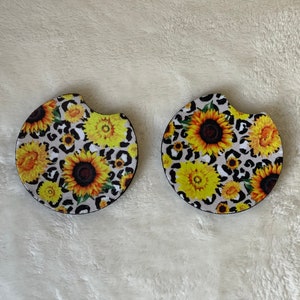 Pair of sunflower neoprene car cup coasters with rubber backing. Catches moisture from beverages. 2.75x2.75.