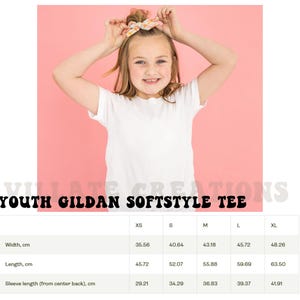 Pode incluir: Uma pessoa jovem vestindo uma camiseta branca, com o texto "YOUTH GILDAN SOFTSTYLE TEE" na parte inferior. A largura da camiseta varia de 35,56 cm a 48,26 cm, e o comprimento de 45,72 cm a 63,50 cm.