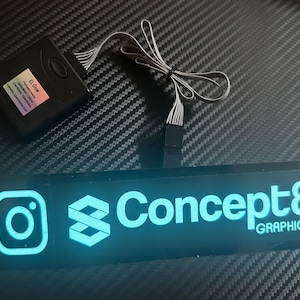 May include: A black rectangular sign with a white "Concept8 GRAPHICS" logo and an Instagram and a stylized 3D infinity symbol in blue. The sign is lit up with blue light.