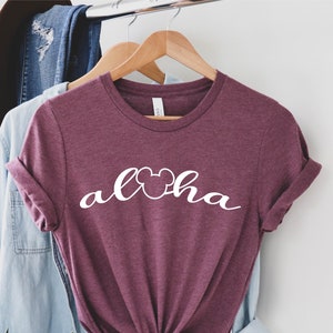 May include: A maroon t-shirt with white text that says "Aloha" with a Mickey Mouse head in the "o".