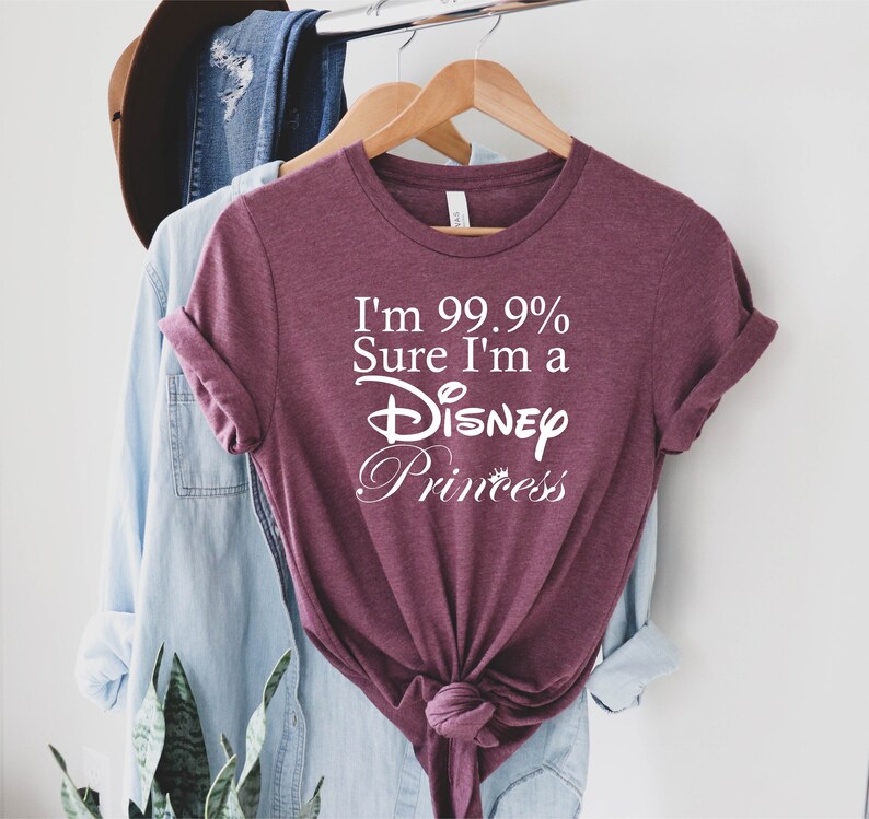 May include: Burgundy t-shirt with white text that reads "I'm 99.9% Sure I'm a Disney Princess".
