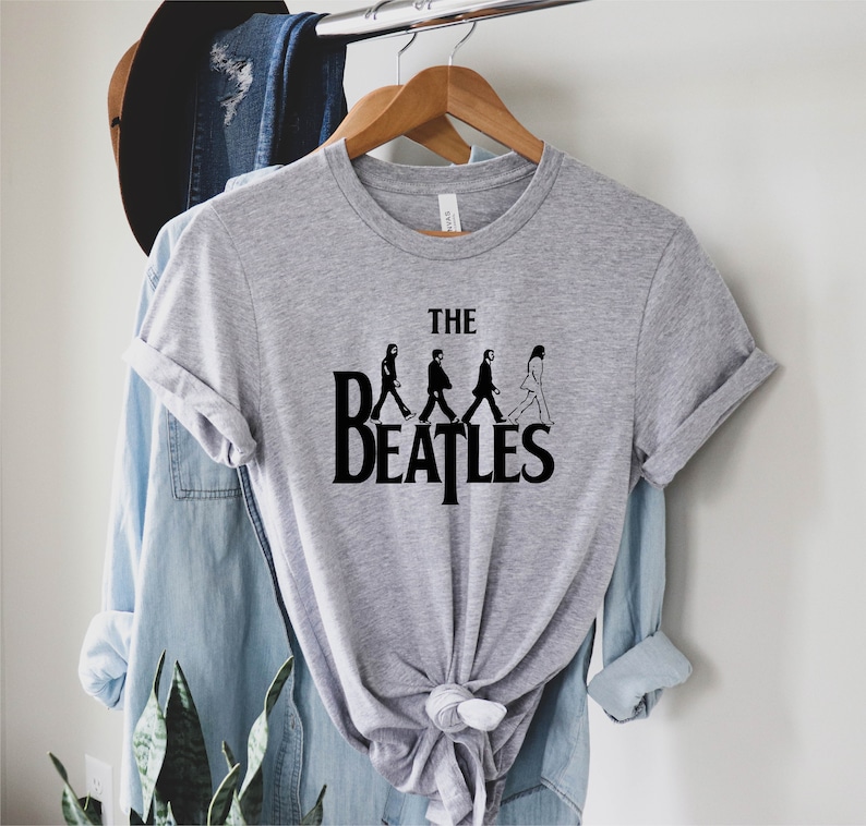 May include: A gray t-shirt with a black graphic of the Beatles walking across a crosswalk with the text "THE BEATLES" underneath.