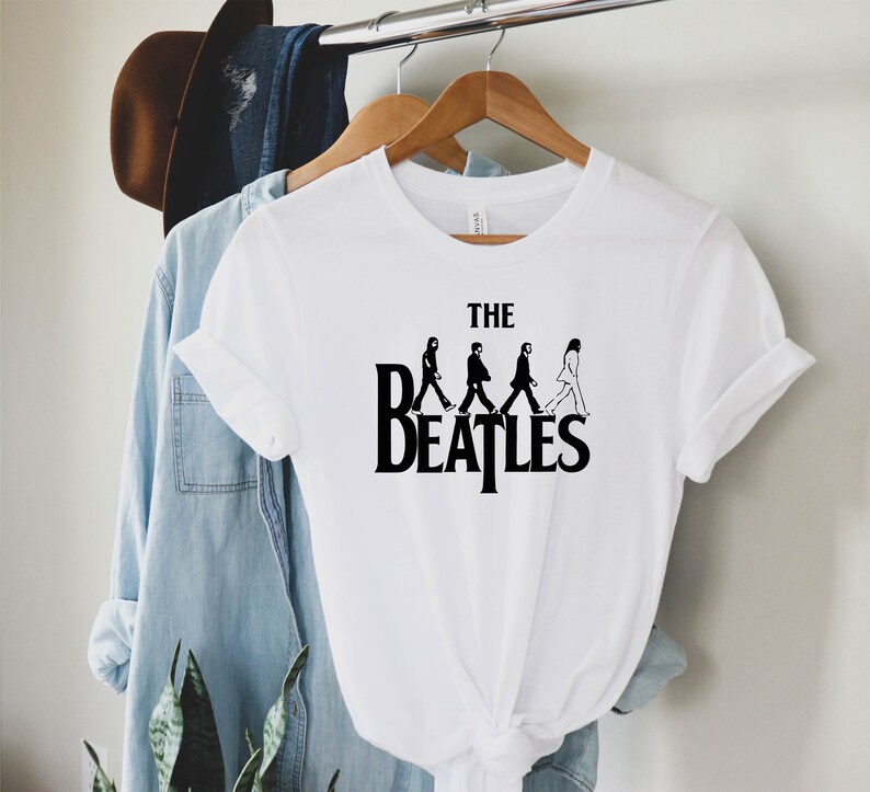 May include: White t-shirt with a black graphic of the Beatles walking across the front. The graphic says "The Beatles" and features the band members in silhouette.
