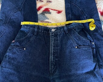 May include: A pair of dark blue denim jeans with a high waist and a relaxed fit. The jeans have a yellow measuring tape around the waist, showing a measurement of 30 inches.