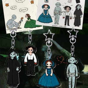 Puede incluir: Una colección de llaveros acrílicos e impresiones artísticas con ilustraciones de dibujos animados. Los llaveros representan varios personajes, algunos con vestimenta formal, con accesorios en forma de estrella. Las impresiones artísticas tienen bocadillos de diálogo y el texto "ZEYNEP'S CINEMA CLUB".