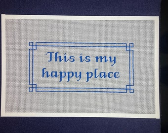 May include: White canvas with a blue embroidered border and the text "This is my happy place" in blue.