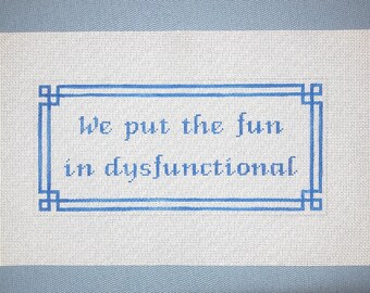 May include: A white canvas with blue embroidery that reads "We put the fun in dysfunctional".
