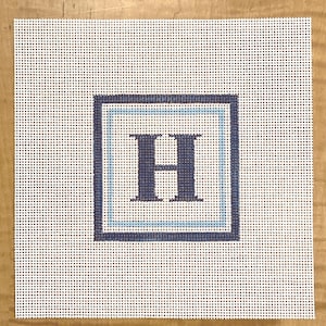 May include: A white canvas with a blue and white border and a navy blue letter "H" in the center.