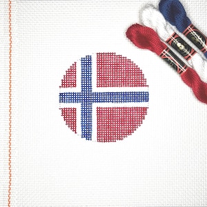 May include: A white canvas with a red, white, and blue circle in the center. The circle is a cross-stitch design of the Norwegian flag. Three spools of embroidery floss are in the upper right corner of the image. The floss is red, white, and blue.