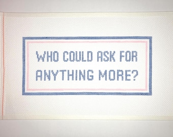 May include: White canvas with blue and pink stitching, featuring the text "WHO COULD ASK FOR ANYTHING MORE?" in blue.