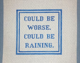 May include: White canvas with blue embroidery that reads "Could be worse. Could be raining."