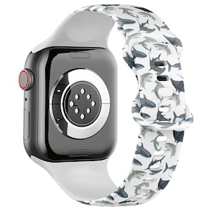 May include: White silicone Apple Watch band with a shark pattern. The band is compatible with Apple Watch Series 4 and later.