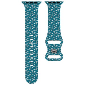 May include: A teal blue Apple Watch band with a white shark pattern.