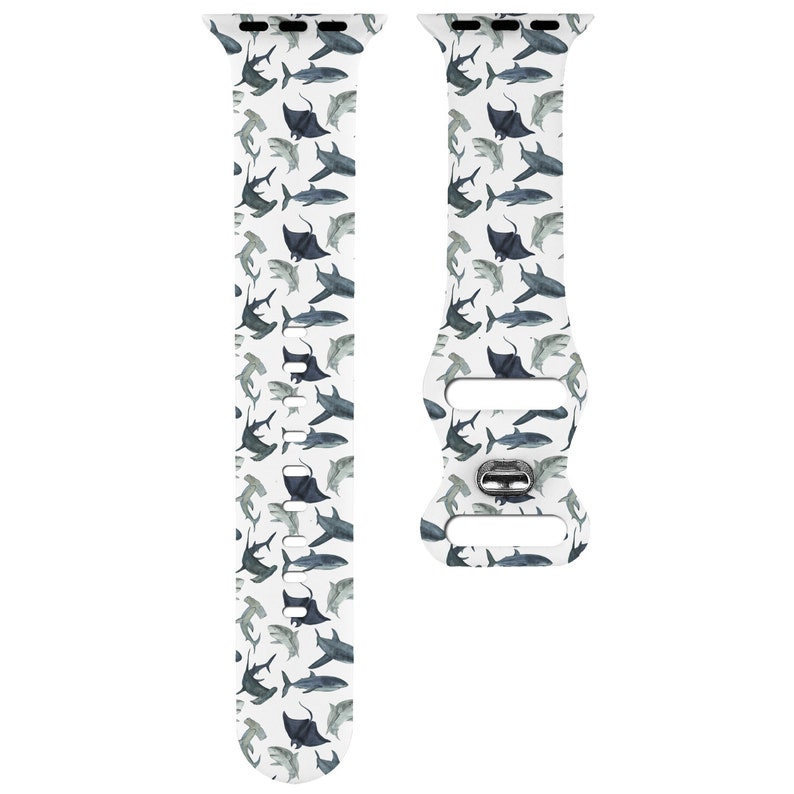 May include: White Apple Watch band featuring a pattern of blue and grey sharks and manta rays.