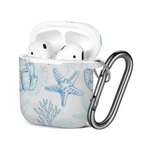 May include: White Airpods case with a blue and white sea life design. The case has a carabiner clip attached.