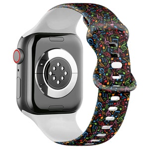 May include: A white and black Apple Watch band with a colorful musical note pattern. The band is made of silicone and has a secure clasp.