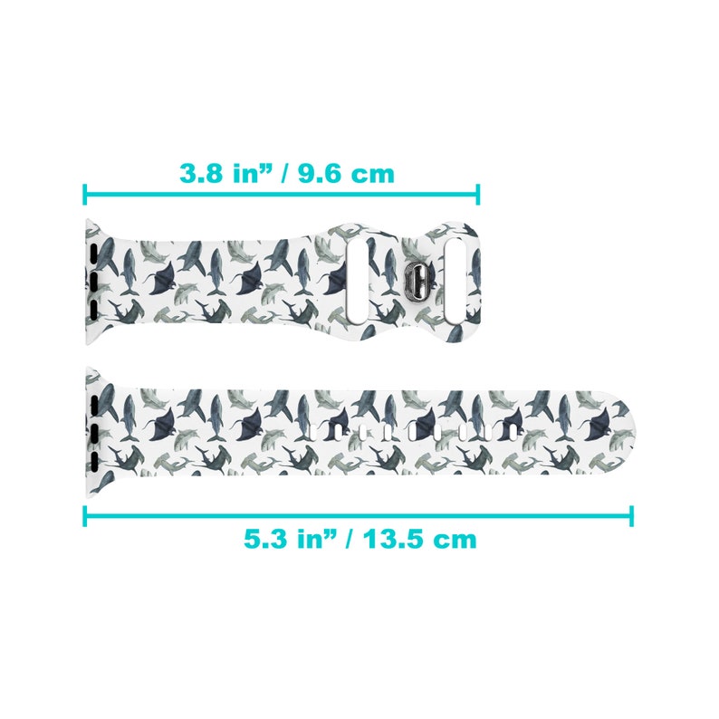 May include: White silicone Apple Watch band with a pattern of blue sharks and stingrays. The band measures 9.6 cm wide and 13.5 cm long.