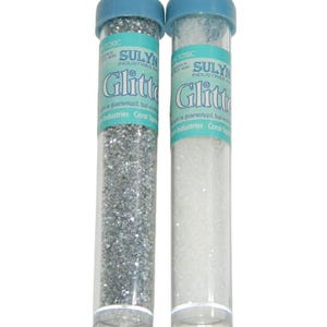 May include: Two clear plastic tubes filled with silver and white glitter. The tubes have blue lids with a loop for hanging. The labels on the tubes read "SULYNN INDUSTRIES Glitter".