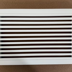 Può includere: Griglia di ventilazione rettangolare bianca con lamelle orizzontali.