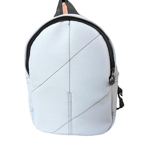 以下が含まれることがあります： 黒いステッチと黒いジッパーが付いた、水色のバックパック。 バックパックは丸みを帯びた形状で、上部に黒いハンドルが付いています。 ステッチは前面に幾何学模様を作り出しています。