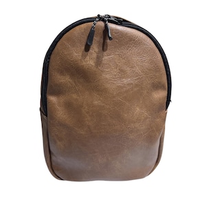 以下が含まれることがあります： 黒いジッパーとトリムが付いた、茶色のフェイクレザーバックパック。バッグは丸みを帯びた上部とテクスチャ加工された表面を備えています。ジッパープルは、白とグレーのコードが付いた黒色です。