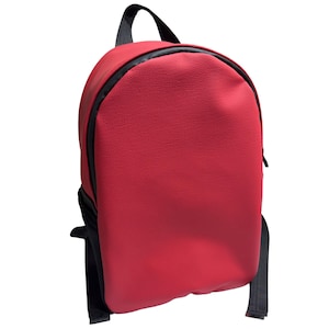 以下が含まれることがあります： 黒いジッパー、ハンドル、ストラップが付いた赤いバックパック。 バックパックは丸みを帯びた形状で、表面はざらざらしています。 ストラップは調節可能です。 バッグは物を運ぶように設計されています。