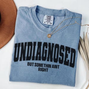Camiseta de colores cómodos sin diagnosticar pero algo no está bien, ropa divertida sarcástica, camiseta médica, camiseta de cuello redondo de salud mental, refranes divertidos