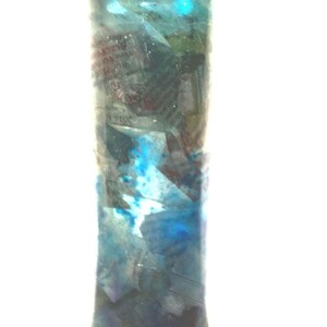 Peut inclure: Un vase en verre cylindrique et haut avec un motif marbré bleu, blanc et gris. Le vase a une base légèrement évasée et une finition lisse et polie.