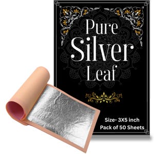 Könnte beinhalten: Eine Packung mit 50 Blatt reinem Silberblatt, jeweils 7,62x12,7 cm groß. Die Verpackung ist schwarz mit weißem Text Pure Silver Leaf und goldenen Verzierungen. Ein einzelnes Silberblatt liegt auf einem pfirsichfarbenen Papier.