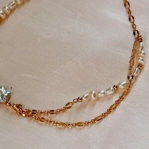 Op de afbeelding: Een delicate gouden ketting met een parelstreng en een stervormige parel hanger.