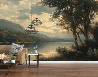 May include: A painting of a lake scene with a mountain range in the background. The lake is calm and the water is reflecting the sky. There are trees on both sides of the lake. The painting is hanging on a wall in a living room. There is a couch, a side table, and a coffee table in the room.