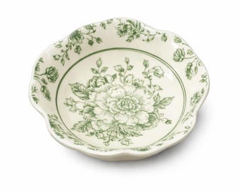 May include: A small, off-white ceramic bowl with a scalloped edge. The bowl features a green floral design in the center and around the rim. The floral pattern includes a large flower and smaller leaves and sprigs.